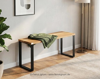 Könnte beinhalten: Holzbank mit natürlicher Oberfläche und schwarzen Metallbeinen. Eine grüne Decke ist über der Bank drapiert. Die Bank befindet sich in einem Raum mit neutralem Farbschema und einem gerahmten Kunstwerk.