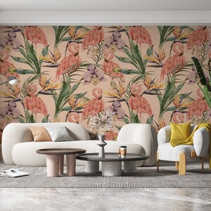 May include: A living room interior design with a pink and green floral wallpaper featuring pink flamingos and tropical plants. The wallpaper is on the wall behind a white sofa and a white armchair with a yellow pillow. There is a coffee table in front of the sofa and a side table next to the sofa.