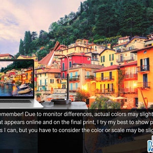 May include: A laptop computer displaying a scenic image of a waterfront town with colorful buildings and boats. The laptop is on a table with a lamp and a glass ashtray.