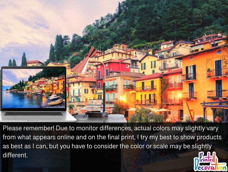 May include: A laptop computer displaying a scenic image of a waterfront town with colorful buildings and boats. The laptop is on a table with a lamp and a glass ashtray.