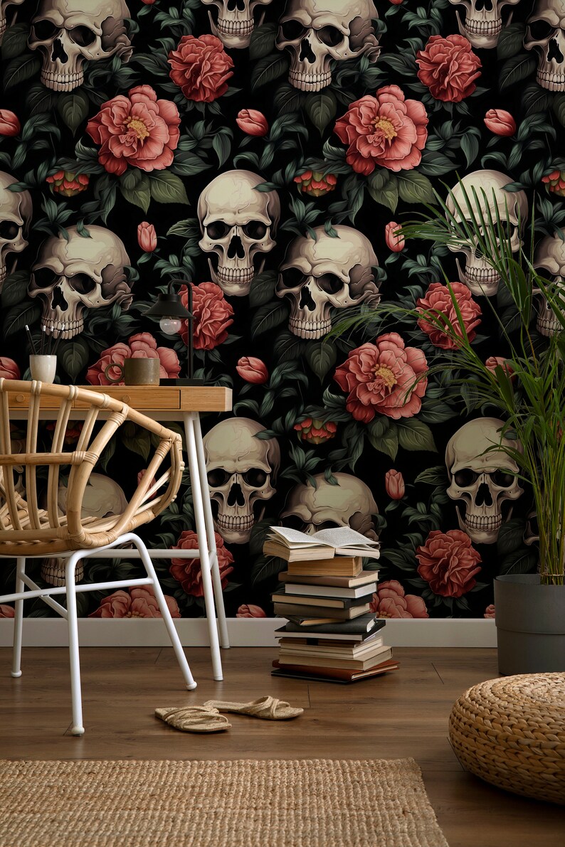May include: A black and white wallpaper with a repeating pattern of skulls and red roses. The wallpaper is in a room with a wicker chair, a stack of books, and a potted plant.