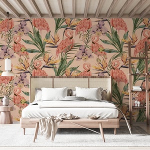 May include: A bedroom with a pink flamingo and tropical leaf patterned wallpaper. The bed has a white duvet and a wooden headboard. There is a wooden side table with a plant on it.
