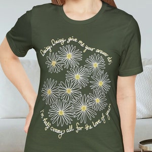 Może przedstawiać: Zielona koszulka z białym wzorem stokrotki i tekstem "Daisy, Daisy give me your answer do, I'm half crazy all for the love of you."