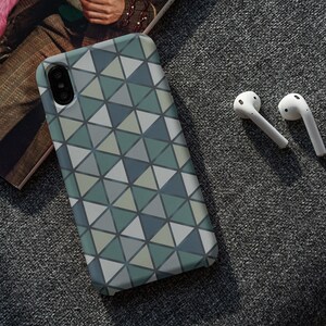 May include: A phone case with a geometric pattern of gray, green, and white triangles.