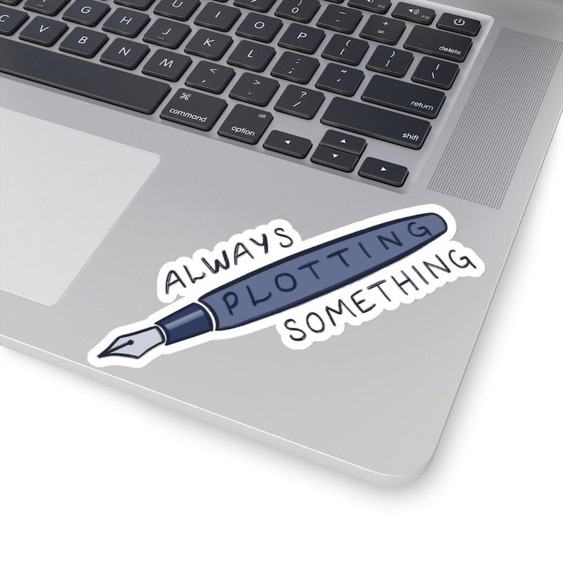 May include: Laptop sticker featuring a dark-blue pen with the text 'ALWAYS PLOTTING SOMETHING' in a handwritten style. The sticker is placed on a silver laptop. The words are written in a casual, informal font. The pen is depicted in a simple, minimalist style. The overall design is clean and modern, suitable for writers, authors, or anyone who enjoys plotting and planning.