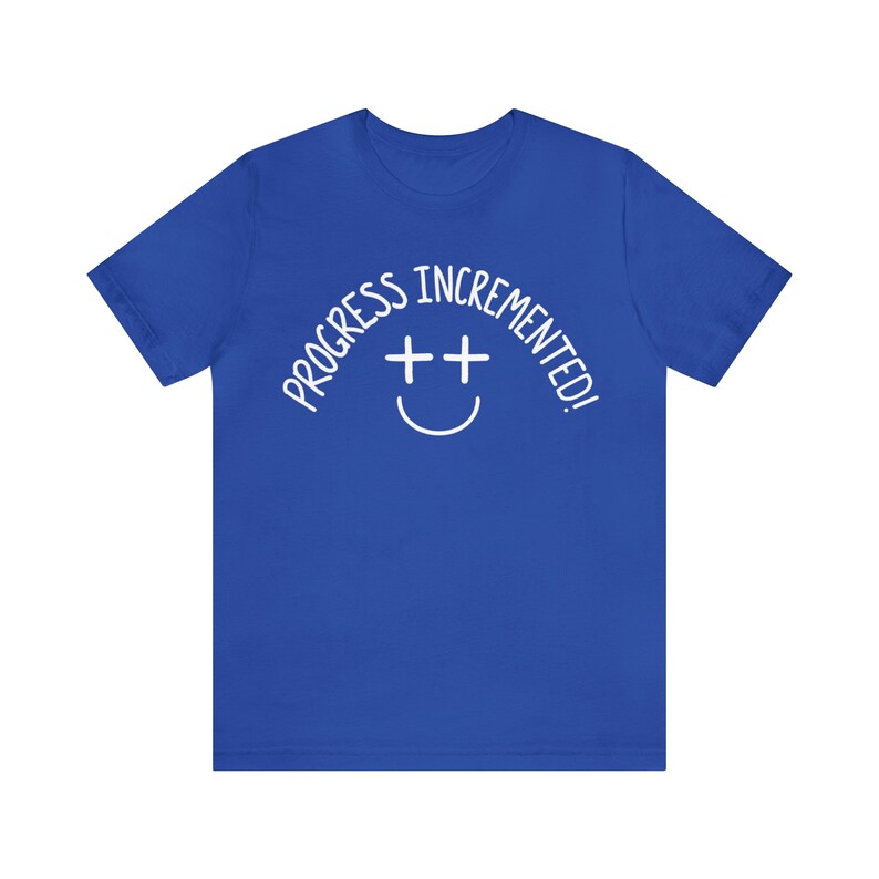 May include: A royal blue t-shirt with a white graphic that says "Progress incremented!" with a smiley face made of two plus signs.