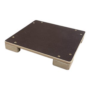 Op de afbeelding: Een vierkant houten platform met een donkerbruine bovenkant en lichtbruine zijkanten. Het platform heeft vier kleine, afgeronde voetjes en is vastgezet met kleine, goudkleurige schroeven. Het platform is ontworpen om objecten te verhogen.