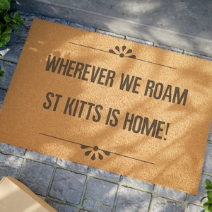 May include: A brown coir doormat with the text "Wherever we roam St. Kitts is home!" printed in black.