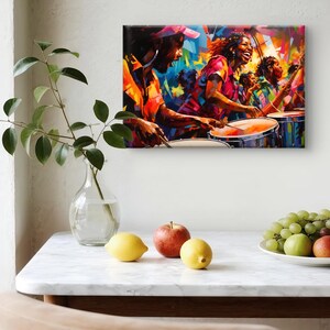 May include: A vibrant, abstract painting depicts a group of people playing drums in a lively, colorful scene. The artwork features bold strokes of orange, red, blue, and yellow, capturing the energy of a musical performance. The painting is displayed on a white wall.