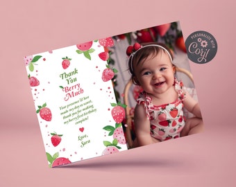 May include: A thank you card with a strawberry theme. The card features a photo of a baby girl in a strawberry-patterned dress. The text on the card reads "Thank You Berry Much" and "Your presence & love made my day so sweet, thank you for making my berry first birthday complete! Love, Sara".