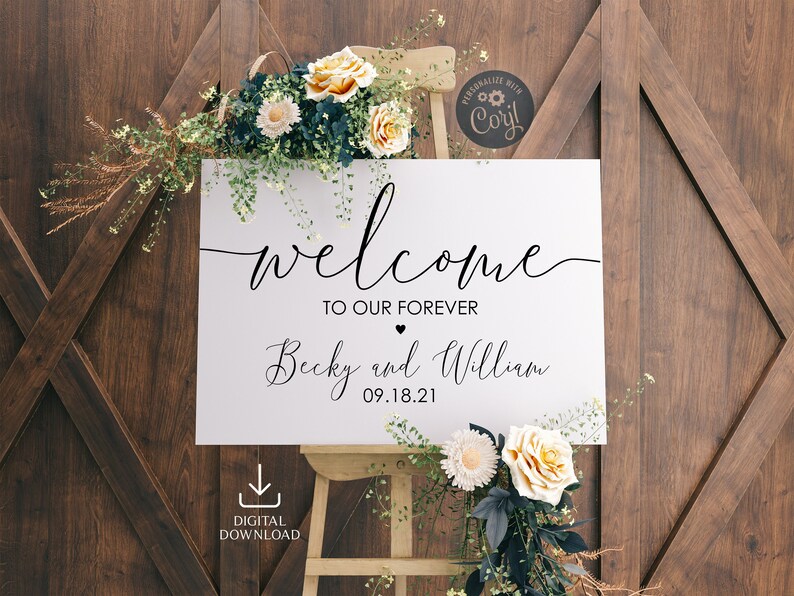 May include: White wedding welcome sign with black calligraphy text that reads "Welcome to our forever Becky and William 09.18.21". The sign is leaning against a wooden easel and surrounded by white and yellow flowers.