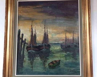 May include: An oil painting in a gold-toned frame depicting a harbor scene with several sailboats moored in calm, dark green water. The sky is a mix of muted orange and deep purple hues. A small rowboat floats in the foreground near wooden pilings.