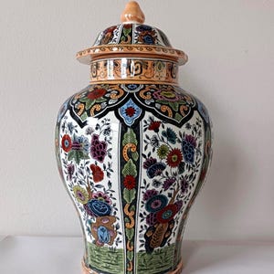 May include: A set of three ceramic mugs with a speckled, matte finish. The mugs are in shades of cream, light gray, and dark gray. Each mug has a simple, minimalist design and a rounded handle. The mugs are likely for coffee or tea.