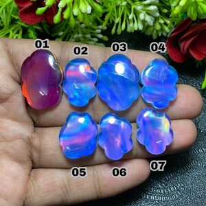 May include: A collection of seven opals in various shapes and colors, ranging from deep purple to vibrant blues and pinks. Each stone has a unique, swirling pattern and a polished, glossy finish. The opals are numbered 01 through 07.