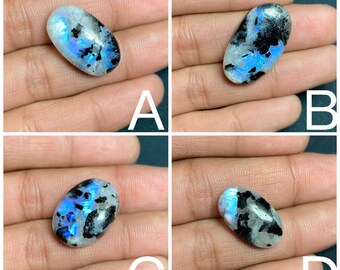 Attraente pietra preziosa sfusa polacca liscia cabochon di pietra di luna bianca arcobaleno completamente blu appariscente con tormalina nera per gioielli avvolti in filo metallico.