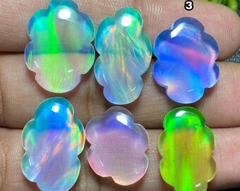 May include: Six opalescent gemstones with a flower-like shape. The gemstones display a range of colors, including green, blue, purple, and pink, with iridescent qualities. Each stone is unique, showcasing different color patterns and light refraction.