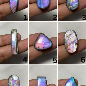 Pode incluir: Uma coleção de nove pedras preciosas de labradorite polidas em várias formas, incluindo corte marquise, oval, pera e retangular. Cada pedra exibe flashes iridescentes de roxo, azul e dourado, numeradas de um a nove.