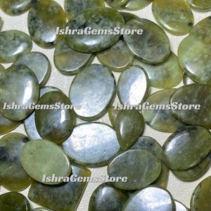 以下が含まれることがあります： 黒と白のマーブル模様が施された、楕円形の緑色のジェイドストーン20個のセット。石は滑らかで磨かれています。石はランダムなパターンで配置されています。画像には「IshraGemsStore」というテキストが3回表示されています。