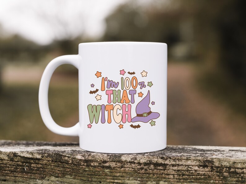 May include: White ceramic mug with a colorful graphic that says "I'm 100% That Witch" with a purple witch hat and stars.