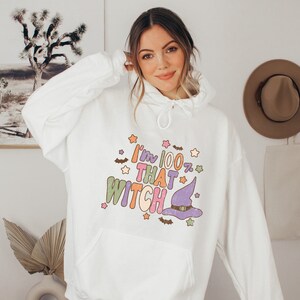 May include: White hooded sweatshirt with a colorful graphic that says "I'm 100% That Witch" with a purple witch hat and stars.