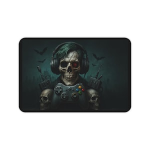 May include: A rectangular mouse mat featuring a skull wearing headphones and holding a video game controller. The skull has green hair and a red eye. The background is dark with bats and a city silhouette.