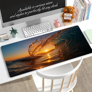 Puede incluir: Alfombrilla de escritorio rectangular con una imagen vibrante de una ola rompiendo al atardecer. La ola está iluminada por el sol poniente, creando un brillo dorado. La alfombrilla está sobre un escritorio blanco con un teclado.
