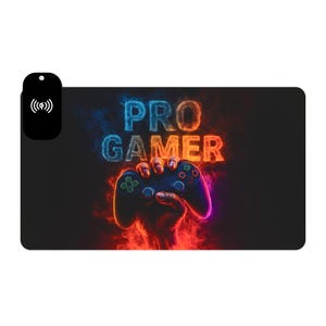 May include: Black rectangular gaming mouse mat featuring the words "PRO GAMER" in blue and orange text. A hand holds a blue and black game controller. A wireless charging symbol is on the left.