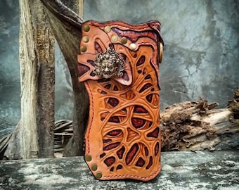 Könnte beinhalten: Ein braunes Leder-Handy-Etui mit aufwendigen Schnitzereien und einem Messing-Löwenkopf-Design. Das Etui hat eine strukturierte Oberfläche und einen roten Unterton.