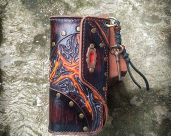 Könnte beinhalten: Eine braune Ledergeldbörse mit einem Schlüsselanhänger. Die Geldbörse hat ein detailliertes Design aus orangefarbenen und schwarzen Flammen. Die Geldbörse hat ein Schlüsselloch-Design auf der vorderen Klappe.