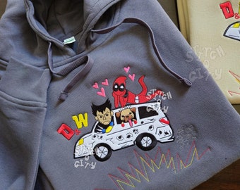 May include: A charcoal gray hooded sweatshirt featuring an embroidered graphic of a white car with a character resembling Wolverine, a dog, and Deadpool on the roof. The design includes pink hearts, the letters D & W, and yellow and red zigzag lines.