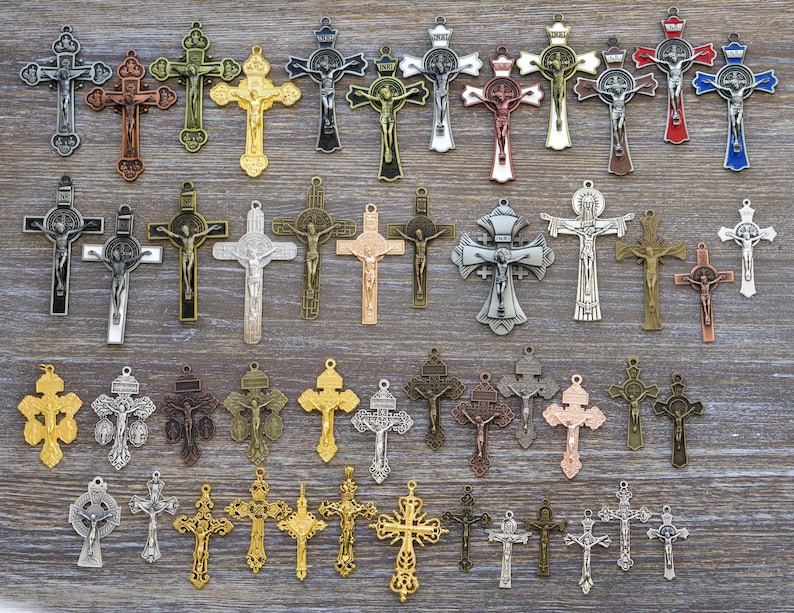 Puede incluir: Una colecci&oacute;n de varios colgantes de crucifijo de metal con diversos dise&ntilde;os, acabados y tama&ntilde;os. El surtido incluye tonos de metal plateado, dorado, bronce, cobre y colores, cada uno representando a Jes&uacute;s en la cruz.