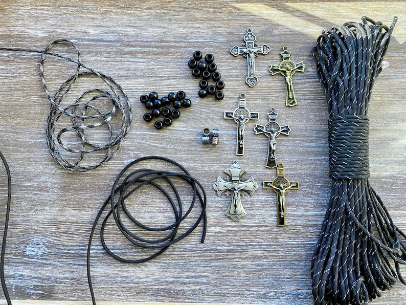 Puede incluir: Un kit de manualidades que incluye un manojo de paracord moteado en blanco y negro, un rollo de cord&oacute;n negro s&oacute;lido, varias cuentas redondas peque&ntilde;as de color negro, dos cuentas espaciadoras met&aacute;licas y seis crucifijos de metal en tonos plata y bronce.