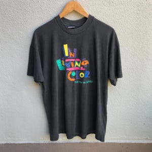 Puede incluir: Camiseta negra con un gráfico colorido de las palabras "In Living Color" y "The Fox TV Series".