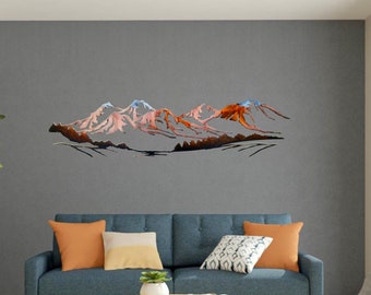 May include: A blue sofa with orange and patterned throw pillows sits in front of a gray wall with a metal wall art sculpture of a mountain range in shades of orange and brown.