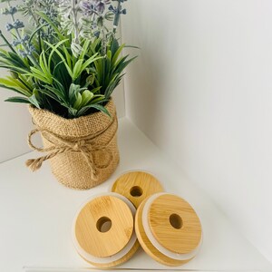 May include: Three round, wooden lids with a silicone ring on the bottom. The lids have a hole in the center. There are also four clear glass straws.