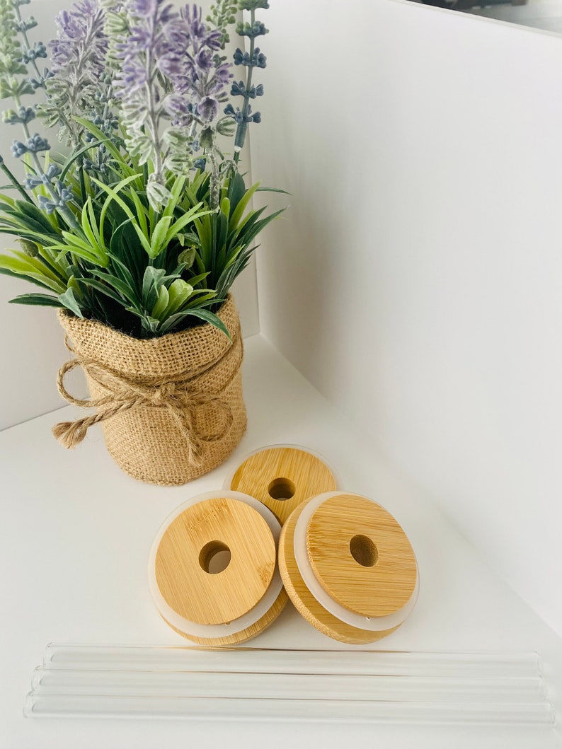 May include: Three round, wooden lids with a silicone ring on the bottom. The lids have a hole in the center. There are also four clear glass straws.
