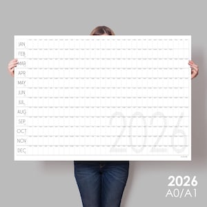 Peut inclure: Un poster de calendrier 2026 blanc et gris avec une mise en page en grille et les mois de l'année énumérés sur le côté gauche. Le poster est tenu par une personne.