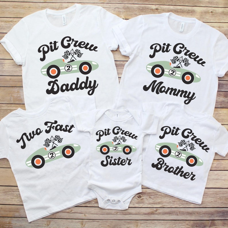 Pu&ograve; includere: Un set di quattro magliette bianche con una grafica di un'auto da corsa verde e il testo "Pit Crew" su ogni maglietta. Le magliette hanno testi diversi sotto la grafica dell'auto: "Daddy", "Mommy", "Sister" e "Brother".