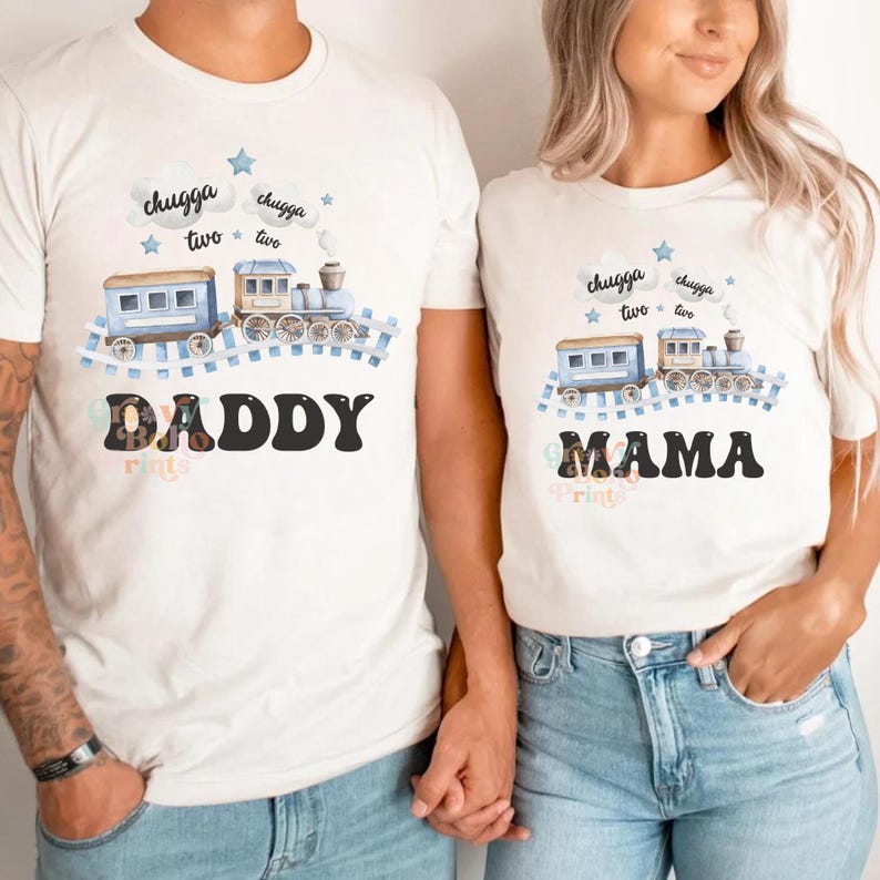 May include: White t-shirts with a blue train design and the words "chugga two chugga two" above the train. One shirt says "Daddy" and the other says "Mama" in a retro font.