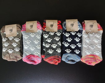 Puede incluir: Cinco pares de calcetines de lana de alpaca con huellas de patas antideslizantes en la parte inferior. Los calcetines son de varios colores, incluyendo gris, marrón, negro y blanco. Los calcetines tienen una etiqueta que dice "Alpaca".
