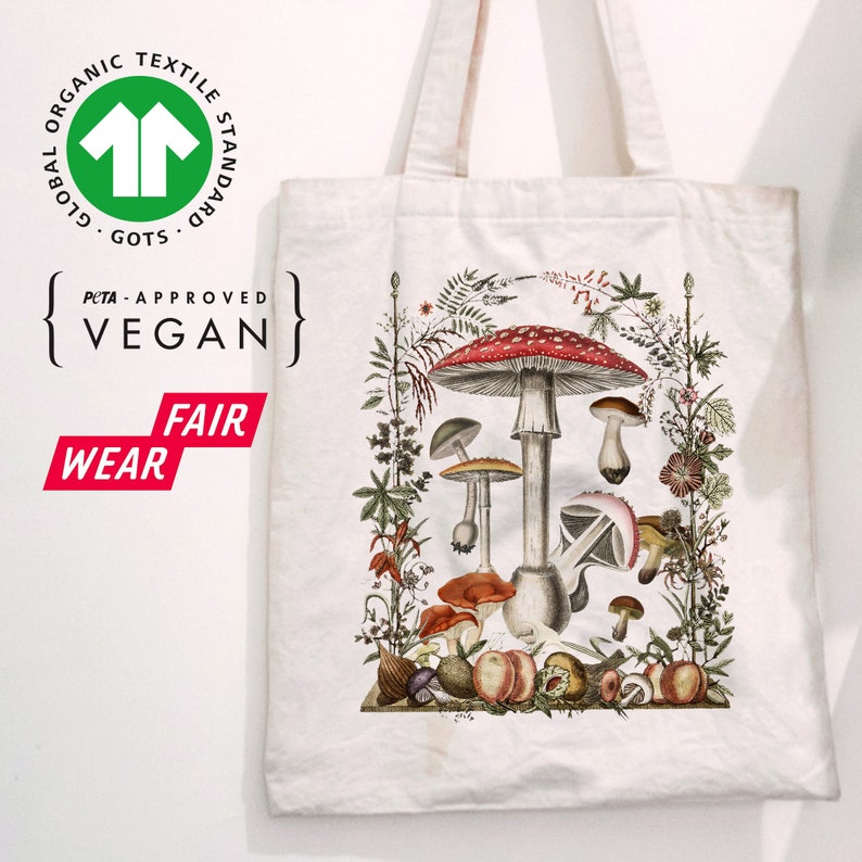 May include: White canvas tote bag with a colorful illustration of mushrooms and foliage. The bag has the text "Global Organic Textile Standard GOTS" and "PETA-Approved Vegan" printed on it.