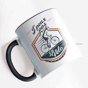 Peut inclure: Mug en céramique blanche avec une anse noire. Le mug présente un graphique d'une personne à vélo avec le texte "J' peux pas j'ai vélo".