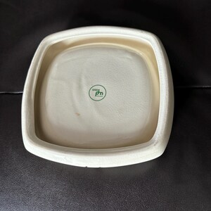May include: White square ceramic dish with a raised rim and a green logo that says "bio pm" on the bottom.