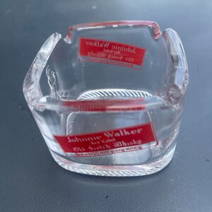 May include: A clear glass ashtray with a red Johnnie Walker label that reads "Born 1820 still going strong".