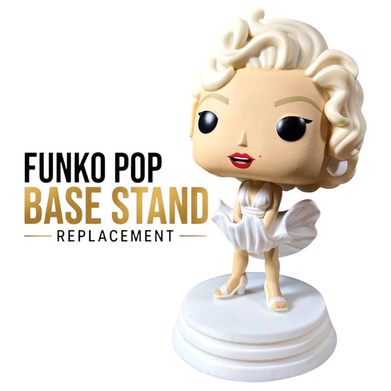 K&ouml;nnte beinhalten: Eine Vinylfigur einer blonden Frau mit einem Sch&ouml;nheitsfleck, die ein wei&szlig;es Kleid tr&auml;gt und auf einem runden wei&szlig;en Sockel steht. Der Text FUNKO POP BASE STAND REPLACEMENT ist links neben der Figur in Schwarz und Gold gedruckt.