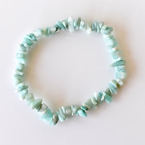 May include: A light blue aquamarine chip bracelet made of small, irregular shaped stones.