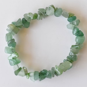 May include: A green gemstone chip bracelet made with natural stones. The bracelet is made with small, irregular shaped chips of green aventurine.