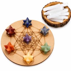 May include: A circular wooden board featuring a laser-engraved geometric pattern, topped with six multi-coloured star-shaped gemstone crystals. Beside the board sits a small, round wooden bowl filled with several white, cylindrical selenite wands.