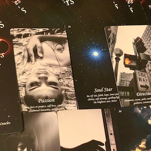 Könnte beinhalten: Ein Satz Tarotkarten mit schwarzen Hintergründen und bunten Bildern. Die Karten zeigen verschiedene Bilder, darunter eine Frau im Wasser, einen Stern, ein Straßenschild und einen Drachen. Die Karten sind mit "Stories of the Stars" betitelt und haben Nummern in den unteren Ecken.