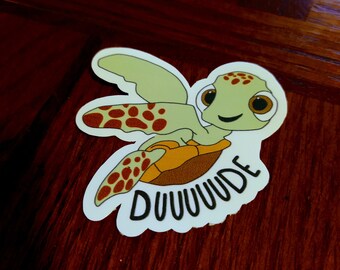 Puede incluir: Una pegatina de dibujos animados de tortuga marina verde con manchas marrones y la palabra "DUUUUDE" escrita en negro. La tortuga sonríe y tiene ojos grandes.